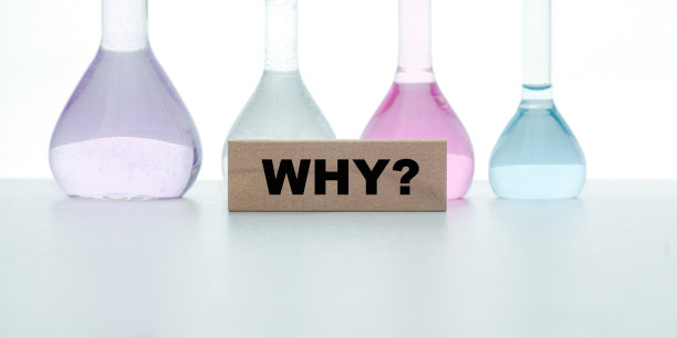 “为什么”写在一块木头上，背景是灰色的化学烧瓶。教育的概念。图片下载