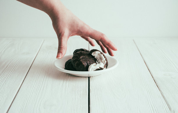 那个女人的手伸向一盘糖果。复古处理添加噪音图片下载