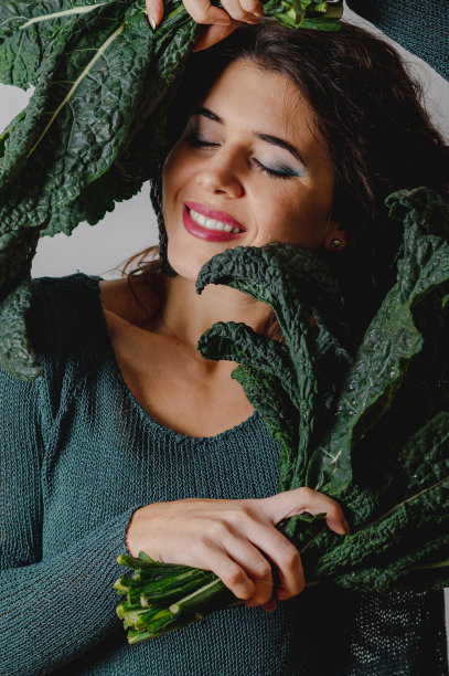 女人在创意极简主义照片与绿叶蔬菜。图片下载