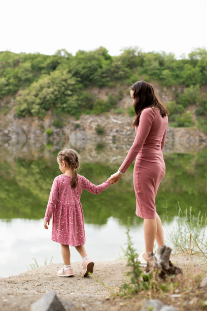 妈妈和女儿站在悬崖边上，欣赏着美丽的景色。图片下载