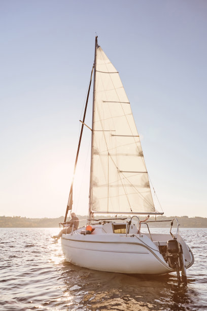 最好的放松。看帆船或游艇漂浮在海上与放松的长者坐在甲板上图片下载