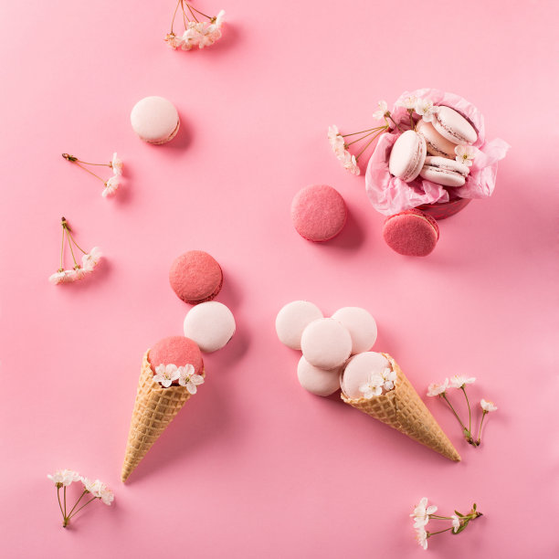 礼品盒里的玫瑰杏仁饼干，樱花，空信封。甜马卡龙呈现在粉红色的背景。图片下载