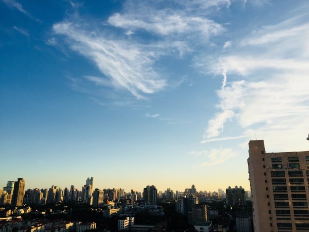 上海疯狂的天空。城市上空的地平线。不同的云，戏剧性的天空，日落。图片下载