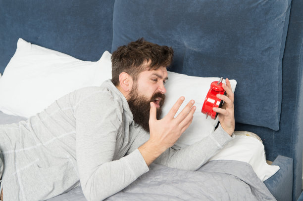 的睡眠阶段。在周末补觉。早上觉醒。闹钟响了，男人不高兴地醒了。虽然你睡着了，但醒来时你可能会觉得根本没有睡过图片下载