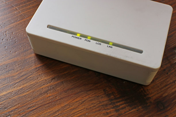 木桌上的白色无线网络路由器。图片下载