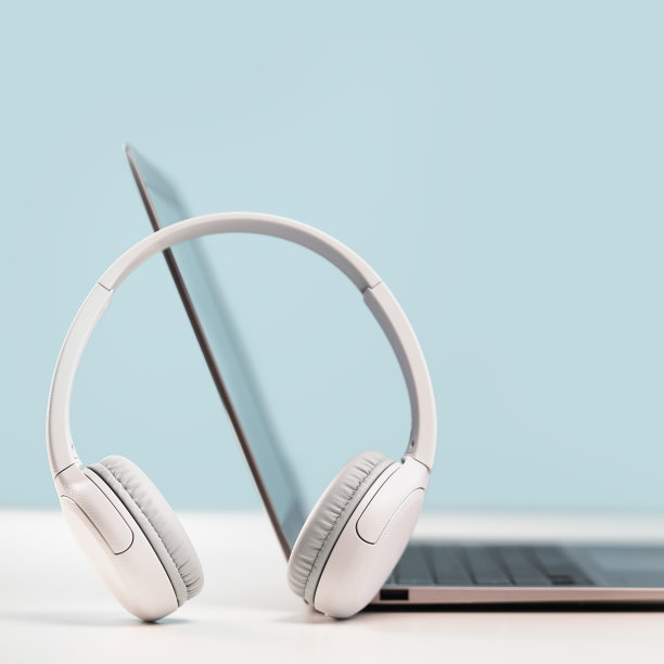 白色桌子上放着带耳机的笔记本电脑图片下载