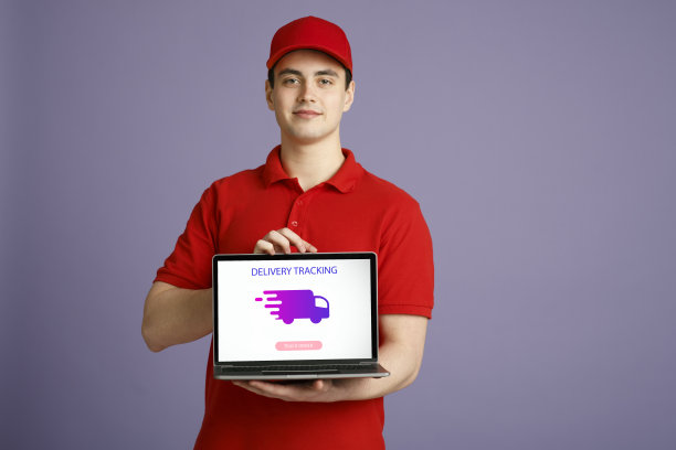 一个年轻人拿着装有快递追踪软件的笔记本电脑图片下载