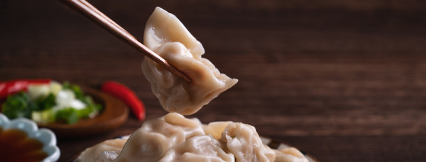 用筷子蘸着酱油吃新鲜水饺。图片下载