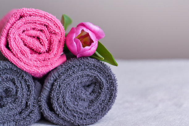 一卷卷新毛巾，上面有粉红色的花图片下载