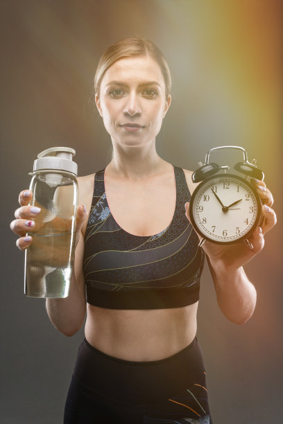 运动白人女孩与苗条的身材建议吃正确的和在时间隔离在黑色背景图片下载