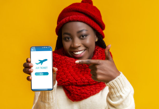 快活的黑人妇女在屏幕上指着智能手机上的机票应用程序图片下载