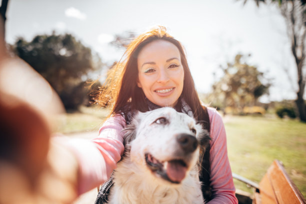 一名妇女抚摸着她的狗并自拍图片下载