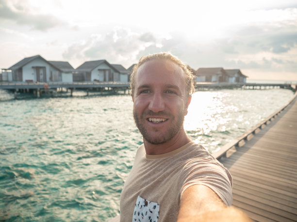 一名男子在马尔代夫一家豪华酒店的码头上自拍图片下载