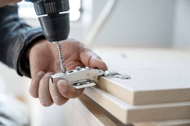 一位工匠搬进了他的新公寓，正在组装橱柜图片下载