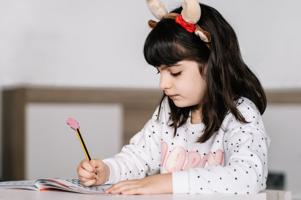 小学女孩在家里的教室里写作素材图片