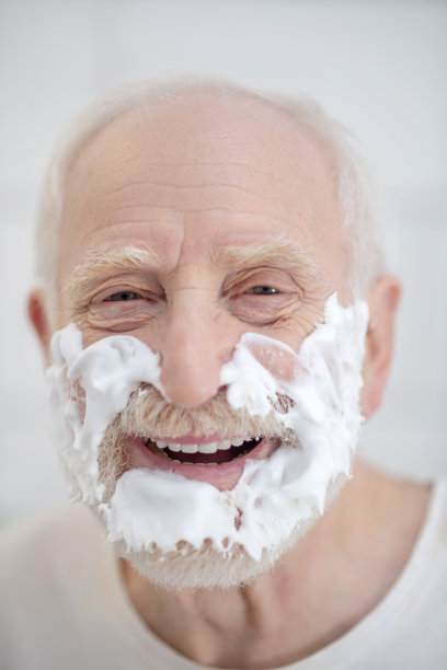 一个脸上有剃须泡沫的男人的特写照片图片下载