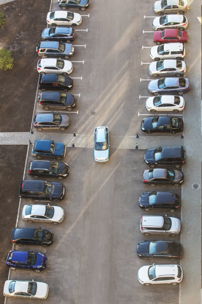 汽车停在一幢住宅楼的院子里。图片下载