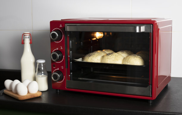 自制的酵母面包是在一个红色的烤箱里烤的。有原料:牛奶，鸡蛋图片下载