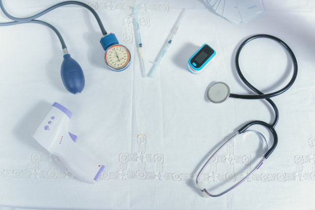 桌子上有医疗设备，温度计，听诊器，注射器图片下载