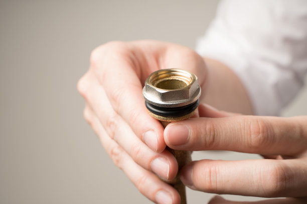 修理阀门丝锥，用手拧紧螺母图片下载