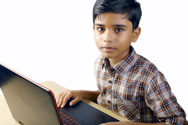 一个印度小男孩在网上上课时使用笔记本电脑图片下载