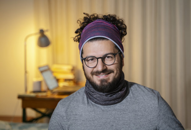 成熟的男人戴着颈圈和大手帕微笑肖像在家图片下载