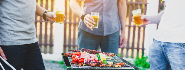 一群朋友在家里的户外烧烤聚会上拿着酒杯喝着啤酒。图片下载