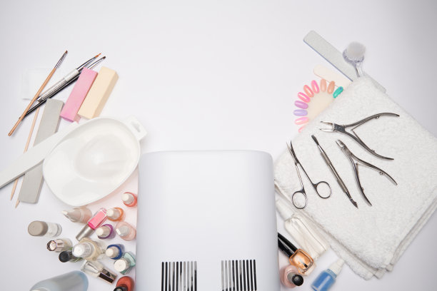 美甲和足部用品-指甲油干燥灯，指甲锉，剪刀和刷子在明亮的背景图片下载