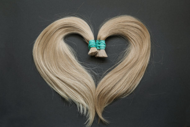 头发以心形的形式在黑色的背景上展开。图片下载