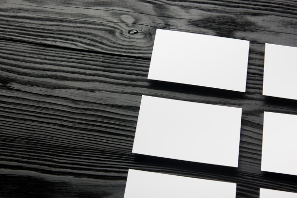 黑色木质背景的空白名片。企业文具，品牌模型。创意设计师的办公桌。平的。文本复制空间图片下载