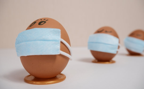 带有病毒防护概念的复活节彩蛋。复活节彩蛋用医用面具来装饰复活节假期。在一个带有copyspace的桃子背景上。图片下载