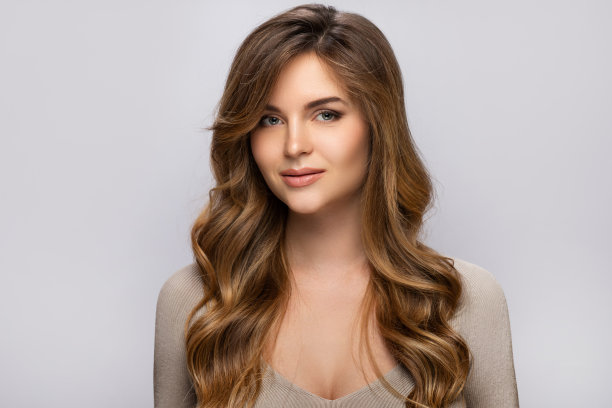 一个年轻漂亮的女人的肖像与卷曲的发型图片下载