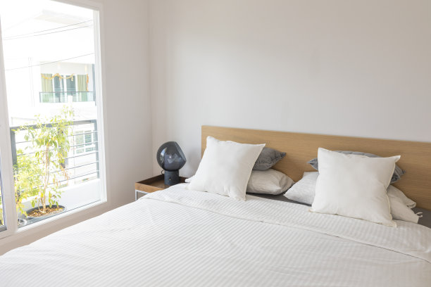 有床头板、床头柜和台灯的特大号床。现代整洁简单的卧室。图片下载