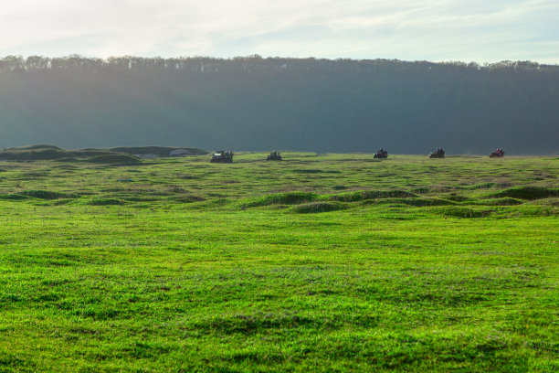 全地形车在绿色的田野上行驶图片下载