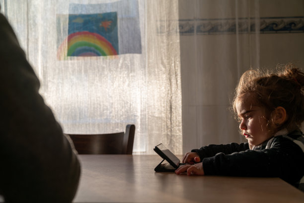 小女孩在家看视频的肖像图片下载