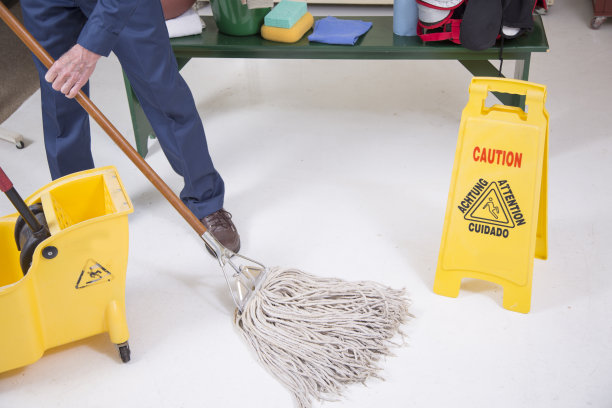 高级成人清洁工在学校的更衣室拖地。图片下载