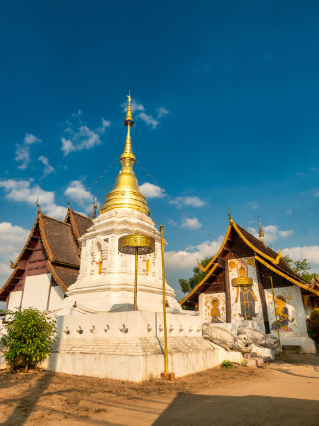 白塔和泰式寺院两栋建筑以蓝天为背景。图片下载