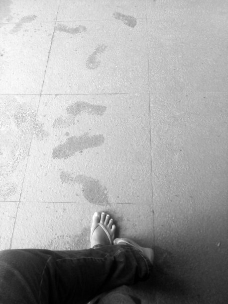 一个人独自站着，有脚印，脚在地板上处于放松的位置。图片下载