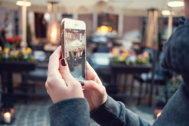 背面近距离观看女性拿着手机与使照片。女人的手用手机设计，手指触摸显示屏图片下载