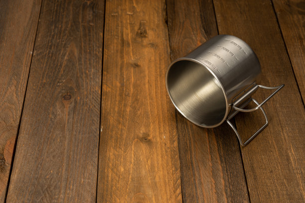 木桌上的空金属杯。副本的空间。图片下载