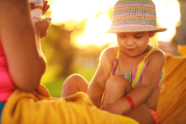 母亲和女儿一起涂抹防晒霜图片下载