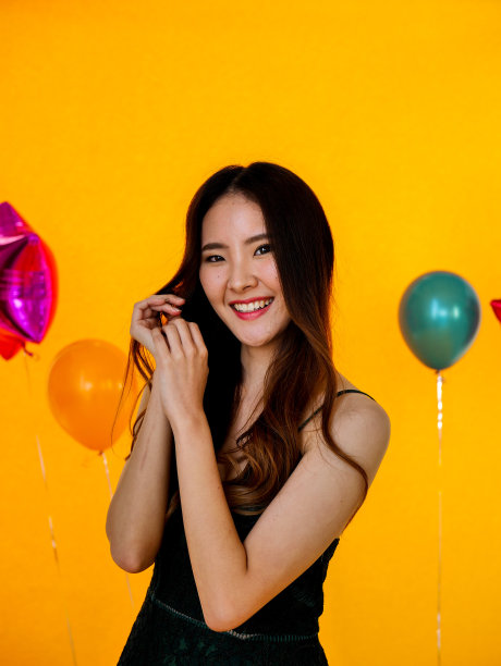 年轻美丽的亚洲女人的肖像站在黄色背景图片下载