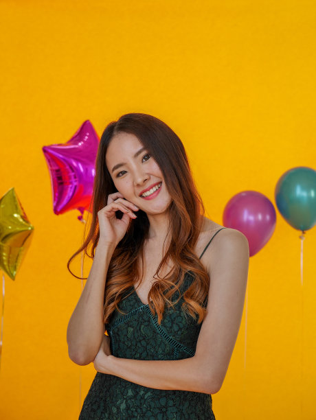 年轻美丽的亚洲女人站在黄色背景的肖像图片下载