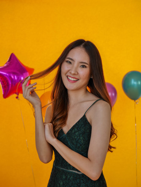 年轻美丽的亚洲女人的肖像站在黄色背景图片下载