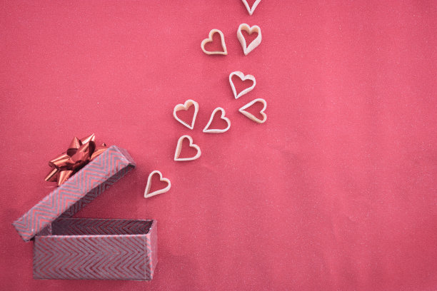 一个里面有粉色心形的礼盒。甜蜜的背景。礼物打开了，心就升起来了。的生日。生日庆祝活动。情人节。周年纪念日。爱的背景。图片下载