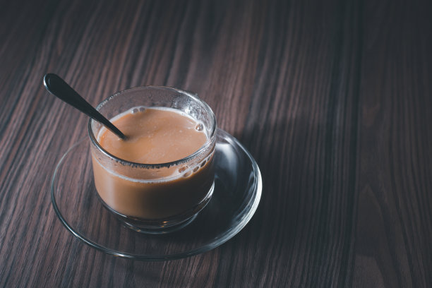 木制背景上放着一个带勺子的咖啡杯图片下载