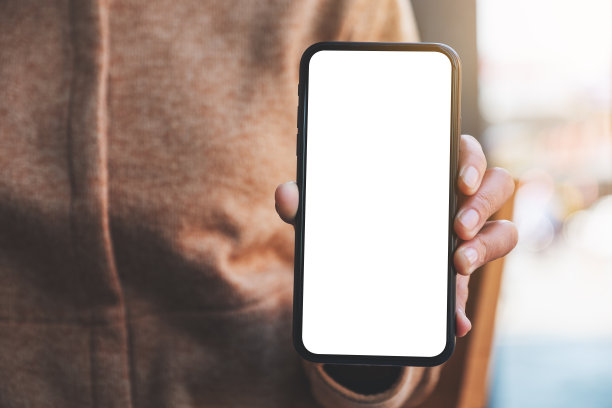 一名女子手持并展示白色手机和黑屏桌面图片下载