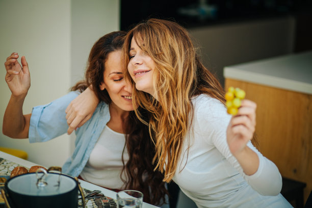 两个女人在家里享用开胃菜和葡萄酒的照片图片下载