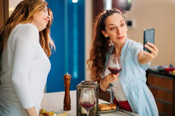 两个女人在家里享用开胃菜和葡萄酒的照片图片下载