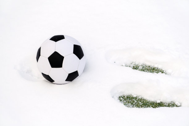 雪地里的足球和雪地里的脚印。图片下载